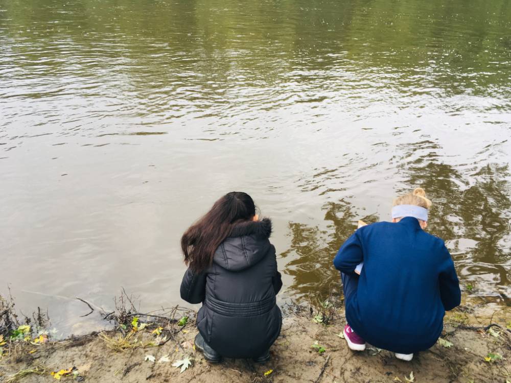 two students looking at the river
